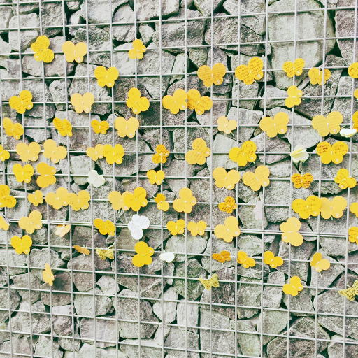 A work of art at the House of Sharing near Seoul depicts butterflies on a wire fence against a rocky wall.